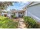 Charming single-story home with blue siding, lush landscaping, and inviting front porch at 39650 Us Highway 19 N # 553, Tarpon Springs, FL 34689