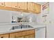 Galley kitchen with stainless sink, stainless dishwasher, and living room view at 39650 Us Highway 19 N # 553, Tarpon Springs, FL 34689