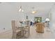 Open-concept living area with vaulted ceilings, dining table, and access to screened porch at 39650 Us Highway 19 N # 553, Tarpon Springs, FL 34689