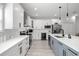 Well-equipped kitchen with white cabinets, stainless steel appliances, a gray island and modern fixtures at 4120 W North A St # 2, Tampa, FL 33609