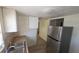 Galley kitchen featuring stainless steel refrigerator, white cabinets, and tiled backsplash at 4607 N 35Th St, Tampa, FL 33610