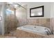 Elegant bathroom with a soaking tub, walk-in shower, and travertine tile at 512 S Glen Ave, Tampa, FL 33609