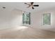 Bright bedroom featuring neutral carpet, a ceiling fan, and large windows offering ample natural light at 512 S Glen Ave, Tampa, FL 33609