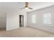Bright, carpeted bedroom featuring natural light from two windows, ceiling fan, and access to a walk-in closet at 512 S Glen Ave, Tampa, FL 33609