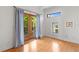 Bedroom with wooden floors, french doors to a balcony, light blue curtains, and natural light at 512 S Glen Ave, Tampa, FL 33609