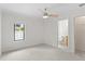 Neutral bedroom featuring carpet, a ceiling fan, window views, and access to the bathroom and closet at 512 S Glen Ave, Tampa, FL 33609