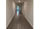 Hallway with wood floors leading to a living area with bright windows at 5407 Kedgewick Ln, North Port, FL 34288