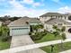 Aerial view showcasing a well-manicured lawn, paver driveway, and tropical landscaping of this single-Gathering home at 5413 Wishing Arch Dr, Apollo Beach, FL 33572