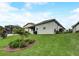 Lush green backyard featuring a well-maintained lawn, landscaping and a screened-in lanai for outdoor entertaining at 5413 Wishing Arch Dr, Apollo Beach, FL 33572