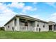 The backyard features a covered patio with a ceiling fan and lush green lawn at 5413 Wishing Arch Dr, Apollo Beach, FL 33572