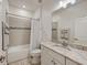 Bathroom with marble countertops, white cabinets, and a combination tub and shower at 5413 Wishing Arch Dr, Apollo Beach, FL 33572
