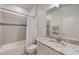 Bathroom with marble countertops, white cabinets, and a combination tub and shower at 5413 Wishing Arch Dr, Apollo Beach, FL 33572