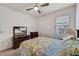 Bright bedroom featuring a floral-patterned comforter, dresser, and a ceiling fan at 5413 Wishing Arch Dr, Apollo Beach, FL 33572