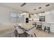 Beautiful dining area featuring elegant lighting, stone table and open layout to the kitchen at 5413 Wishing Arch Dr, Apollo Beach, FL 33572