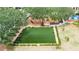 Aerial view of a fenced dog park with artificial turf, seating, and shade trees at 5413 Wishing Arch Dr, Apollo Beach, FL 33572