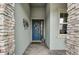 Inviting entryway with a stylish blue door, stone accents, and decorative elements at 5413 Wishing Arch Dr, Apollo Beach, FL 33572