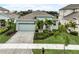 Attractive single-Gathering home boasting a two-car garage, paver driveway, and vibrant landscaping with palm trees at 5413 Wishing Arch Dr, Apollo Beach, FL 33572