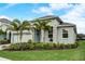 Charming home with a two-car garage, manicured lawn, palm trees, and stone accents at 5413 Wishing Arch Dr, Apollo Beach, FL 33572
