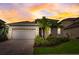 Charming single-Gathering home featuring a two-car garage, a well-manicured lawn, and lush tropical landscaping at 5413 Wishing Arch Dr, Apollo Beach, FL 33572