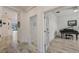 Bright hallway with tile flooring, leading to various rooms including an office with a piano at 5413 Wishing Arch Dr, Apollo Beach, FL 33572