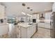 Open kitchen boasts a large center island, pendant lighting, and views of the living area at 5413 Wishing Arch Dr, Apollo Beach, FL 33572