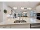 Bright kitchen with white cabinets, granite countertops, stainless steel appliances and modern pendant lighting at 5413 Wishing Arch Dr, Apollo Beach, FL 33572