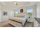 Bright main bedroom featuring tray ceilings, neutral walls, and a view of the community pond at 5413 Wishing Arch Dr, Apollo Beach, FL 33572
