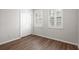 Bedroom featuring wood flooring, plantation shutters, and white trim and walls at 5613 Kingsley Corner Way, Lithia, FL 33547