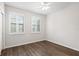 Bedroom featuring wood flooring, plantation shutters, and white trim and walls at 5613 Kingsley Corner Way, Lithia, FL 33547