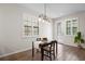 Dining area with modern lighting fixture, wood flooring, and plantation shutters at 5613 Kingsley Corner Way, Lithia, FL 33547