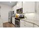 Bright kitchen with stainless steel appliances, white cabinets, and modern countertop at 5613 Kingsley Corner Way, Lithia, FL 33547