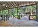 Covered wooden patio with outdoor seating overlooking lush greenery and boardwalk at 5613 Kingsley Corner Way, Lithia, FL 33547