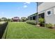 Spacious backyard featuring manicured lawn, privacy fence, and a screened lanai for outdoor enjoyment at 5717 Village Center Dr, Lithia, FL 33547