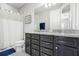 Bathroom boasts granite countertop, sleek dark cabinets, framed mirror, and tiled floor at 5717 Village Center Dr, Lithia, FL 33547