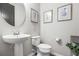 Powder room with pedestal sink, framed art, and toilet at 5717 Village Center Dr, Lithia, FL 33547