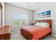 Bright bedroom showcasing a wooden bed frame, large window, and dresser at 5717 Village Center Dr, Lithia, FL 33547