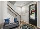 Inviting entryway featuring a decorative door, stylish staircase, and a cozy seating area with accent pillows at 5717 Village Center Dr, Lithia, FL 33547