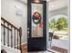 Stylish foyer featuring a decorative front door and staircase with metal spindles at 5717 Village Center Dr, Lithia, FL 33547