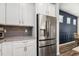 Kitchen boasts stainless fridge, gray backsplash, and granite countertops at 5717 Village Center Dr, Lithia, FL 33547