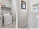 Functional laundry room with washer, dryer, storage shelving, and a window at 5717 Village Center Dr, Lithia, FL 33547