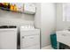 Bright laundry area featuring a washer, dryer, shelving, and utility sink at 5717 Village Center Dr, Lithia, FL 33547
