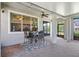 Outdoor patio space with ceiling fan, dining table and chairs, brick flooring at 5717 Village Center Dr, Lithia, FL 33547