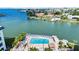 Community pool overlooking stunning bay views, lounge chairs, and tropical landscaping at 6025 Shore S Blvd # 409, Gulfport, FL 33707