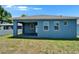 A view of the backyard showcasing the covered patio and the freshly painted blue exterior at 6097 Vermont Ave, New Port Richey, FL 34653