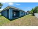A view of the backyard featuring a covered patio and a freshly painted blue exterior at 6097 Vermont Ave, New Port Richey, FL 34653