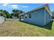 A spacious backyard featuring a covered patio and a freshly painted blue exterior at 6097 Vermont Ave, New Port Richey, FL 34653