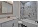 Bathroom featuring stylish vanity with marble countertop and tiled shower and tub combo at 6097 Vermont Ave, New Port Richey, FL 34653