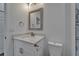 Bathroom featuring a single sink vanity with a white cabinet and a framed mirror at 6097 Vermont Ave, New Port Richey, FL 34653