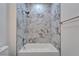 Bathroom with white marbled tile surrounding the tub and shower area at 6097 Vermont Ave, New Port Richey, FL 34653