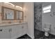 Modern bathroom features a dual sink vanity, a marble-tiled shower, and black and white tile flooring at 6097 Vermont Ave, New Port Richey, FL 34653